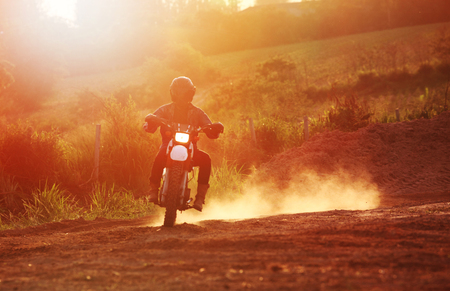 Motocross turn on dirt track or rider creates a huge cloud of dust and debrisの写真素材