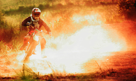 Motocross turn on dirt track or rider creates a huge cloud of dust and debrisの写真素材