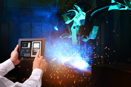 Industry 4.0 , Engineer check and control welding robotics automatic arms machine.  in intelligent factory automotive industrialの写真素材