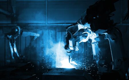 automate wireless Robot arm in smart factory background. Mixed media of welding robot in the automotive parts industryの写真素材