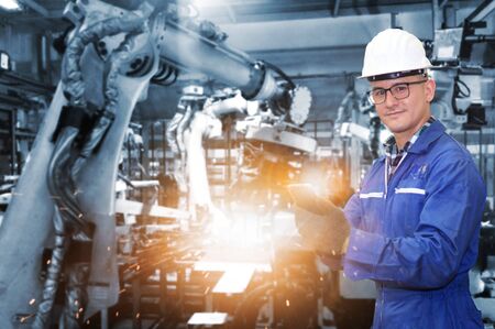 Production engineer with automate wireless Robot arm in smart factory background. Mixed media of...