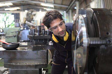 Factory Engineer Operating big machine cut off material for industry concept の写真素材