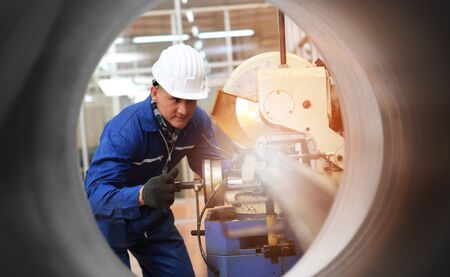 Male  Industrial Engineers in Hard Hats  with  machine. Assist production engineer in industry. He checking or push metalwork control in industrial In a plastic factory for car. Concept Successful Of Work.の写真素材