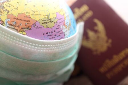 medical mask on the background of the world map Concept: mortality from coronavirus, global pandemic, infection with a deadlyの写真素材