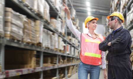 Businessman and woman are  standing at office of warehouse, they are planning management smart logistic conceptの写真素材