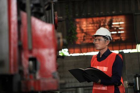 Factory Engineer checking big machine cut off material for industry conceptの写真素材
