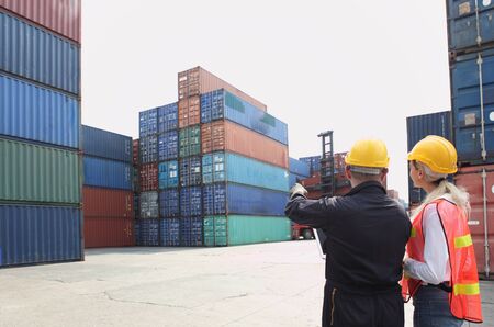 Engineering group working and they are loading container for support logistics and import export businessの写真素材