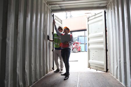 Engineering group working and they are loading container for support logistics and import export businessの写真素材