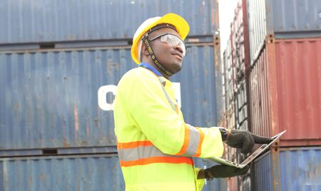 Close up of An African American handsome black engineer he is working in container box yard area for...