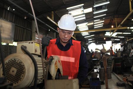 Factory Engineer operating big machine cut off material for industry concept