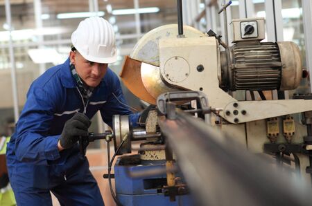 Factory Engineer operating big machine cut off material for industry concept