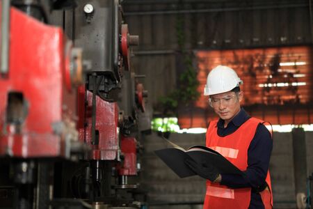 Male  Industrial Engineers in Hard Hats  with  machine. Assist production engineer in industry. He checking or push metalwork control in industrial In a plastic factory for car. Concept Successful Of Work.の写真素材