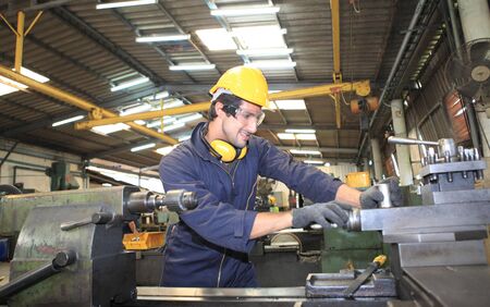 Factory Engineer operating big machine cut off material for industry concept