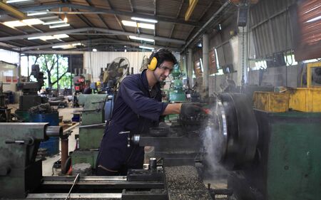 Factory Engineer operating big machine cut off material for industry conceptの写真素材