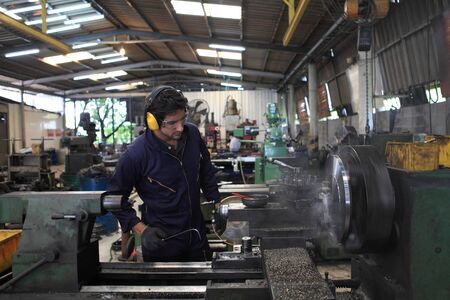 Factory Engineer operating big machine cut off material for industry conceptの写真素材