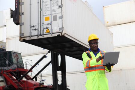 Close up of An African American handsome black engineer he is working in container box yard area