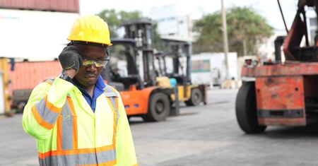 Close up of An African American handsome black engineer he is working in container box yard area