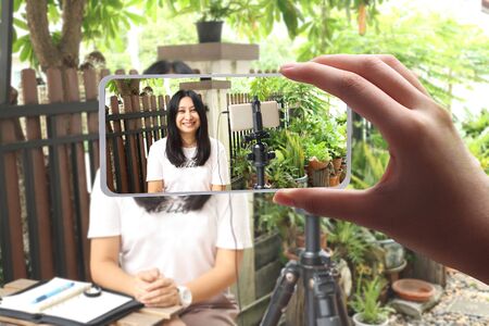 woman working from home , Behind the cellphone shooting video,movie,vlog digital. beautiful asian...