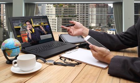 businessman working at a home office with a laptop on table. VDO conference call with business partner group.Concept of male freelancer business.の写真素材