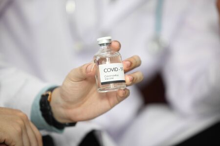Doctor holding sample covid-19 vaccine vial with medication, closeup.の写真素材