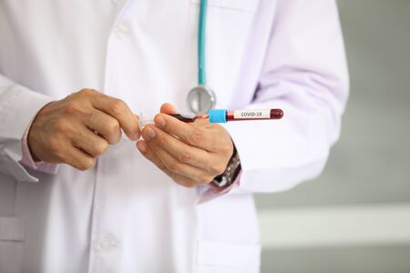 Doctor holding sample covid-19 vaccine vial with medication, closeup.の写真素材
