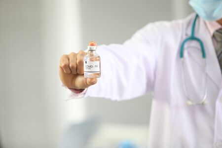 Doctor holding sample covid-19 vaccine vial with medication, closeup.の写真素材