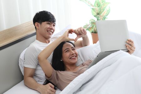 couple love using  laptop on bedroom   ,  work from home. Technology and communicationの写真素材