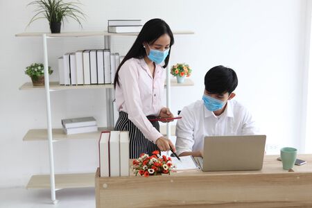 couple in quarantine for Coronavirus wearing protective mask and work from homeの写真素材