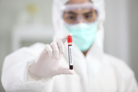 Laboratory research. Team work Scientists  study data and evaluating microscope success. they are doing research with dropper chemical testing life science and find vaccine for covid 19の写真素材
