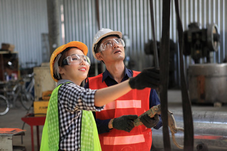 Male and Female Industrial Engineers with  machine. Assist production engineer in industry. He checking or push metalwork control in industrial In a plastic factory for car. Concept Successful of Work.の写真素材