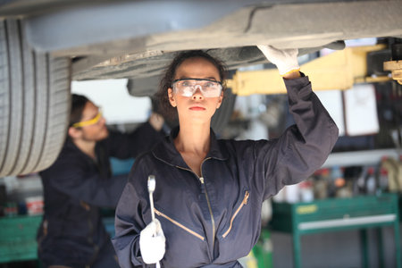 Portrait of a mechanic at work in his garage or car repair service or auto store, business, maintenance and people conceptの写真素材