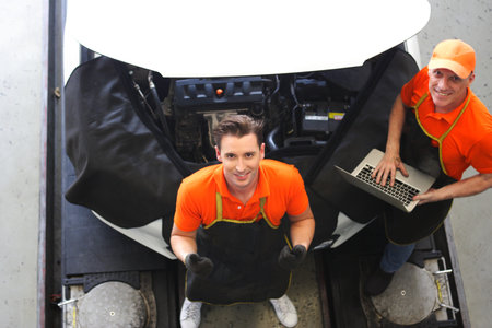 car mechanic use notebook computers to check engine and service maintenance of industrial to engine repair, for transport automobile automotive , top view imageの写真素材