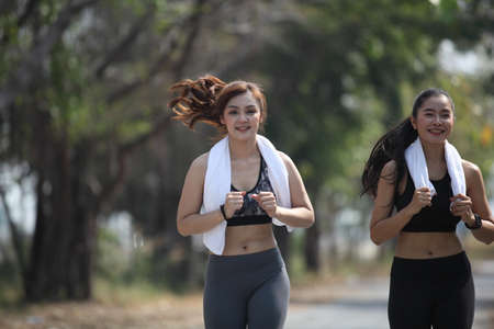 runner - woman running outdoors training for marathon run. Beautiful fit asian fitness model in her 20s.Sporty woman runner. Photo of attractive woman in fashionable sportswear. Dynamic movement. Sport and healthy lifestyleの写真素材