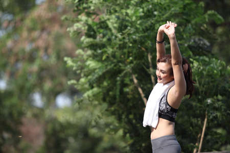 Fitness runner body closeup doing warm-up routine before running, stretching arm muscles with...