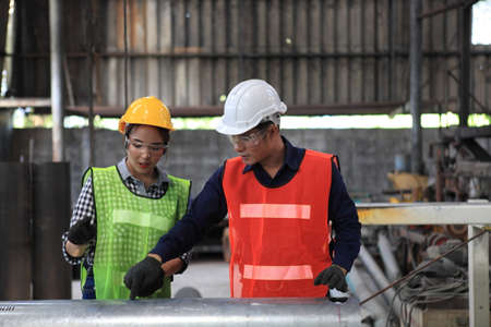 Male and Female Industrial Engineers with  machine. Assist production engineer in industry.  checking metalwork control in industrial In a plastic factory for car. Concept Successful of Work.の写真素材
