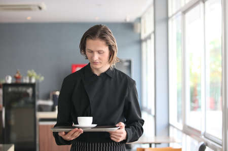 A  Handsome male barista is working in coffee shopの写真素材