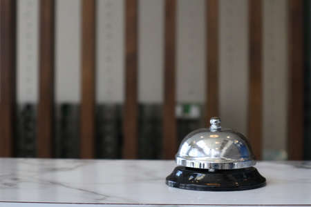 Hotel service bell on a table white glass and simulation hotel background. Concept hotel, travel, roomの写真素材