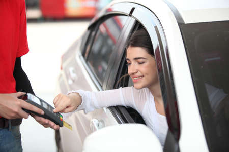 woman refill oil pay credit card , woman in car paying credit card after refuel car spending instead...