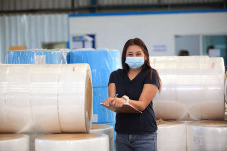worker woman  with mask on face she are checking stock at  warehouseの写真素材