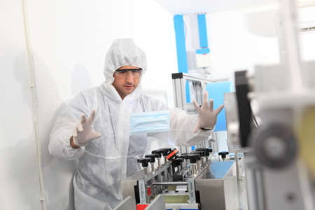 Production engineer with face mask working in factory , Qc engineer checking mask for good quality , Concept of protective action and quarantine to stop spreading of Coronavirus Disease 2019の写真素材