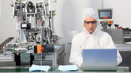 Production engineer with face mask working in factory , Qc engineer checking mask for good quality , Concept of protective action and quarantine to stop spreading of Coronavirus Disease 2019の写真素材