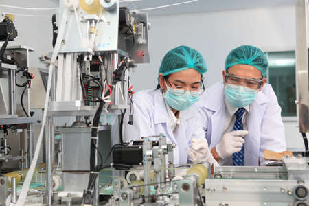Production engineer with face mask working in factory , Qc engineer checking mask for good quality