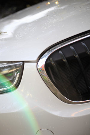 Close up front of new car parking , Modern car headlight close up photoの写真素材