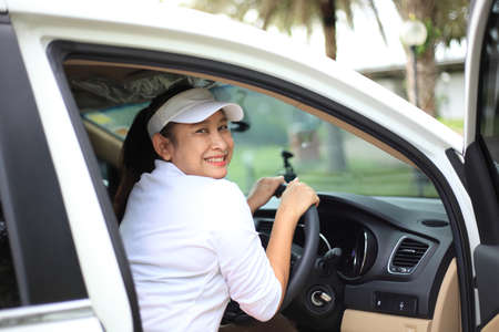 Portrait of happy female driver steering car with safety belt , Happy woman driving a car and smiling. happy brunette woman is driving a car.の写真素材
