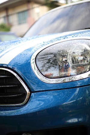 Close up front of new car parking , Modern car headlight close up photoの写真素材