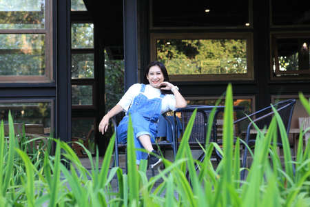 woman relax in garden , Relaxed young female smiling and looking side, sitting on home terrace....
