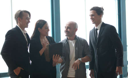 team young business people working and communicating while standing at the office with city building...