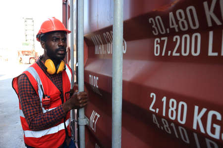 logistics background for delivery business or transportion industry,African American engineer working in container area  logistics transportation import export or shipping industry free-zone areaの写真素材