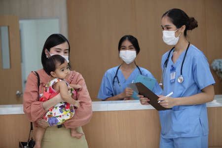 Busy Nurse's Station In Modern Hospital, Group of doctors with face masks help people , corona virus...