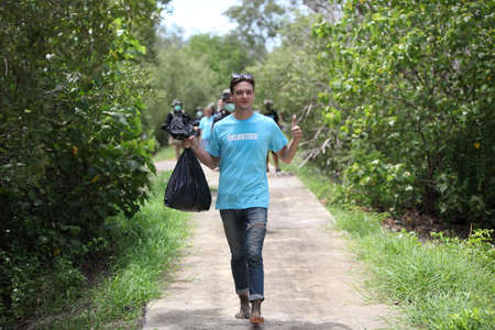 Happy volunteer working , volunteering, charity, cleaning, people and ecology concept - group of...